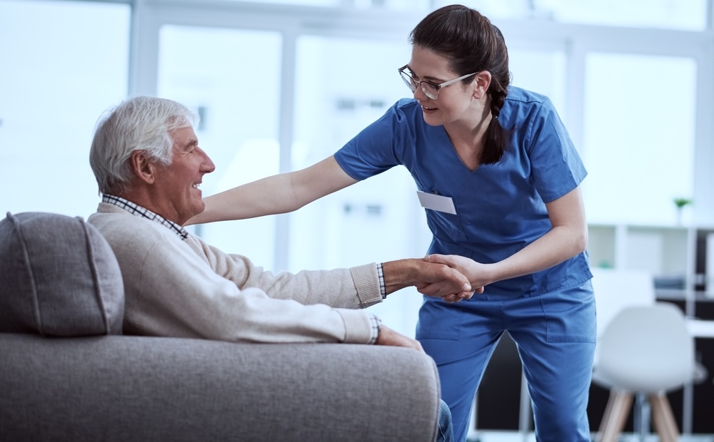 A female nurse attending to a male senior